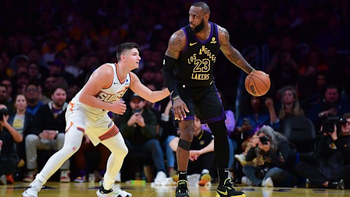 Los Angeles Lakers forward LeBron James moves the ball against Phoenix Suns guard Grayson Allen.